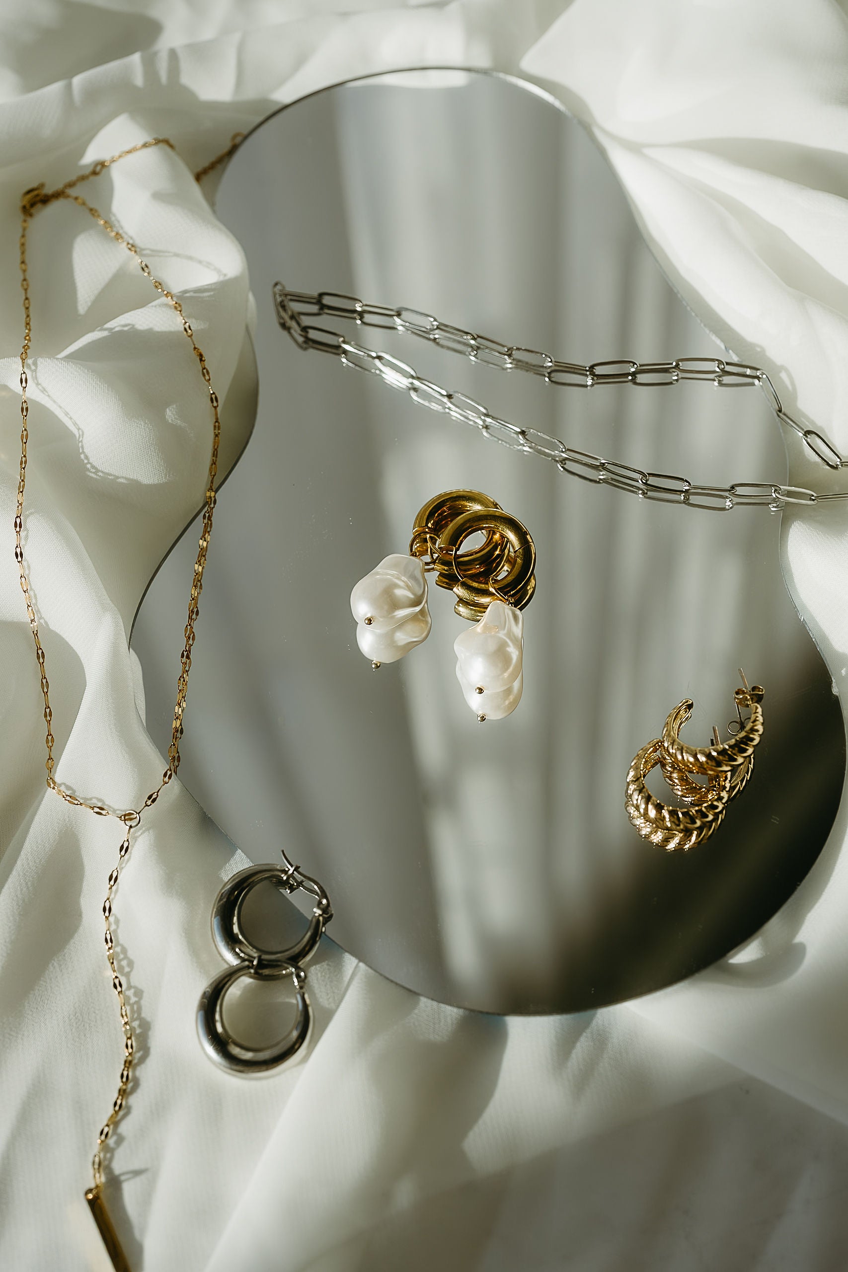 Gold and pearl jewelry set on a white surface